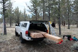 A load of lumber in the back of a pickup truck